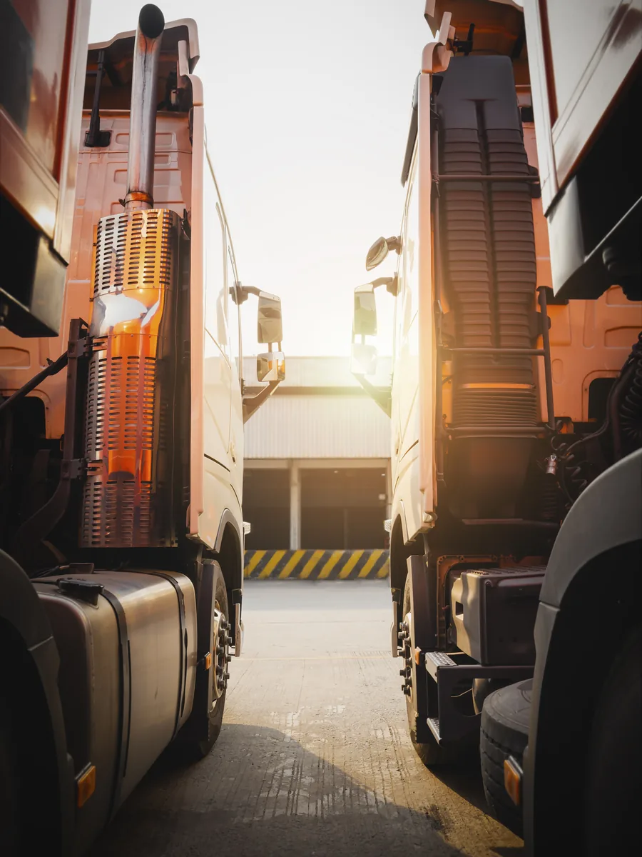 Semi-trucks at a logistics warehouse, AI for freight and logistics operations